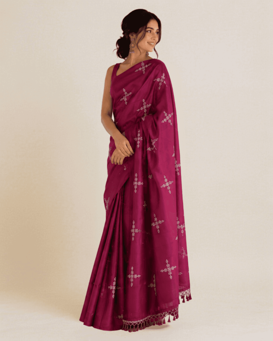 Model wearing a magenta silk-cotton saree with hand-embroidered silver sequin star butis and a beaded tassel border, front view