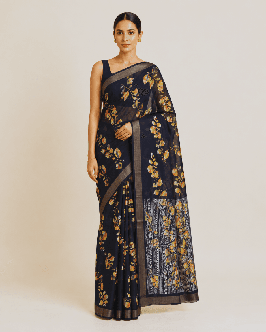 Model wearing a midnight-navy georgette saree with a watercolour leaf print and gold zari border, front view