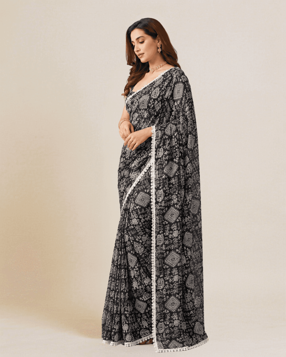 Jet-black Warli-print georgette saree, side profile showing the scalloped lace border